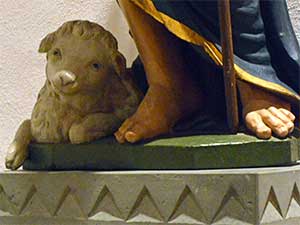 Lamm bei der Patronsfigur in der Alten Kirche St. Johann Baptist Refrath